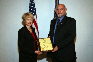 In July, Jim Silcott, chapter small business officer, presents a plaque to Jan Long, a manager at Advanced Technical Intelligence Center (ATIC), in recognition of ATIC's new corporate membership.
